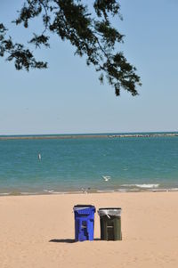 View of calm beach against clear blue sky