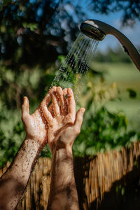 Close-up of hand holding plant against blurred background