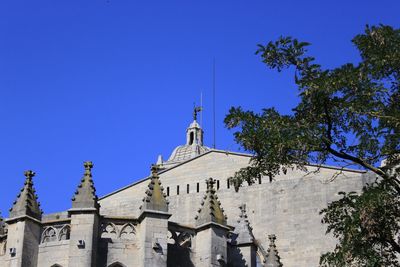 Low angle view of girona cathedral against clear blue sky