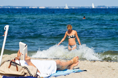Rear view of woman sitting on beach