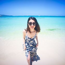 Portrait of young woman standing on beach