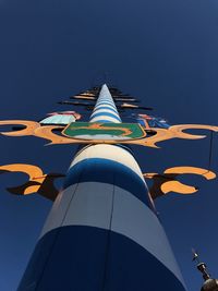 Low angle view of flags against clear blue sky