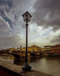 Bridge over river against sky in city