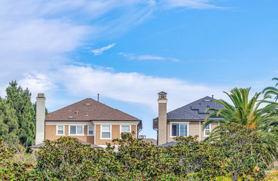 Low angle view of palm trees and building against sky