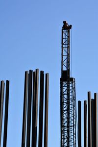 Low angle view of crane against clear blue sky