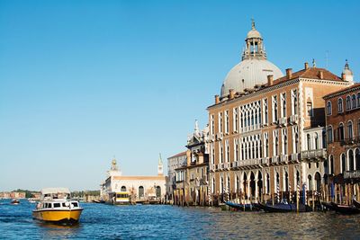 View of canal amidst buildings against clear sky