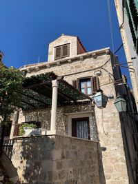 Low angle view of old building against clear blue sky