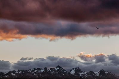 Scenic view of snowcapped mountains against dramatic sky