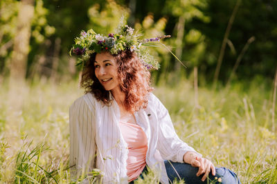 Portrait of young woman sitting on field