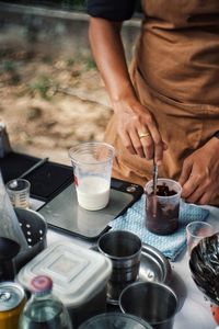 Midsection of woman holding drink on table