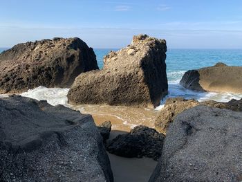 Rocks on beach against sky