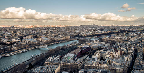 High angle view of city by river against sky