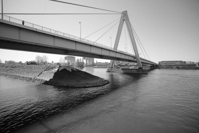 Bridge over river in city against clear sky