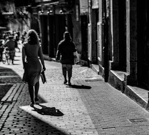 Rear view of people walking on street