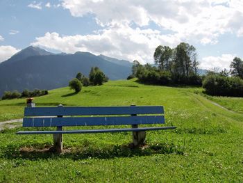 Scenic view of field and mountains against sky