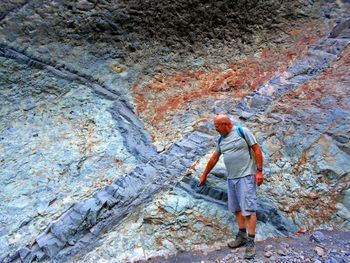 Full length of man standing on land by rock formation