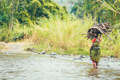 Rear view of woman standing in lake