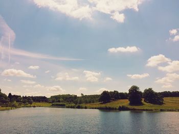 Scenic view of river against cloudy sky