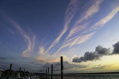 Scenic view of sea by buildings against sky during sunset