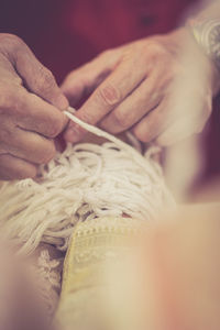 Cropped hands of woman tying bride wrist