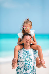 Midsection of mother and daughter on beach