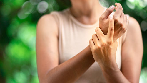 Midsection of woman suffering from hand pain