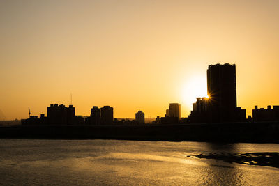 Silhouette of buildings against sky during sunset