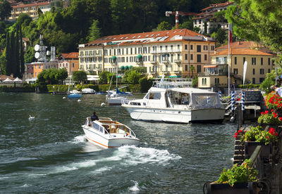 Boats in river against built structures