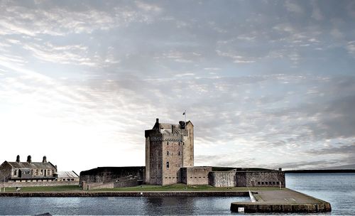 Tower by sea against sky