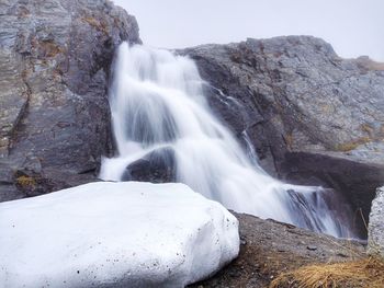 Scenic view of waterfall against sky