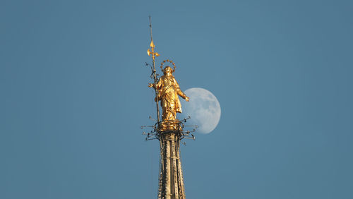 Low angle view of statue against clear blue sky