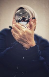 Midsection of man holding eyeglasses at home