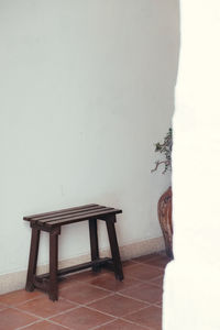Empty chair and table against wall at home