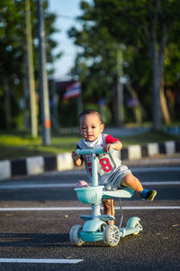 Asian boy playing plow scooter, child cuteness