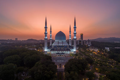 Buildings in city against sky during sunset