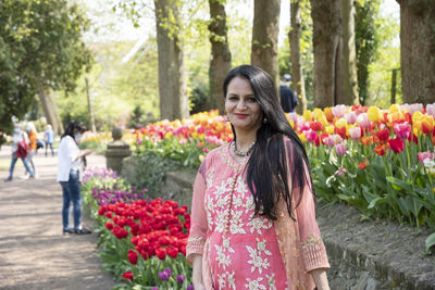 A beautiful indian woman with black hair in a national indian pink sari dress