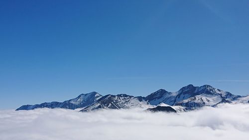 Scenic view of snowcapped mountains against blue sky