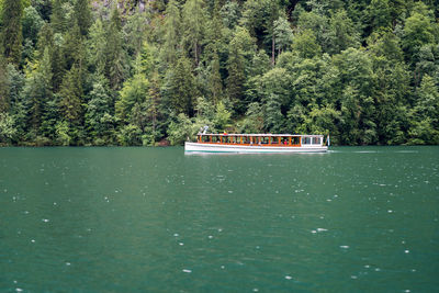 Boat sailing in lake against trees