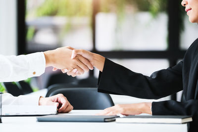 Midsection of business people shaking hands