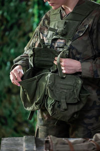 The young woman checks her pockets to make sure she has all the accessories needed for the mission.