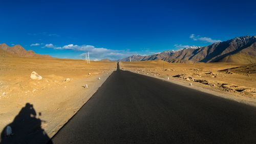 Scenic view of desert road against sky