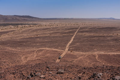An aerial view of a lonely suv on the harrat kishb volcanic field, makkah province, saudi arabia
