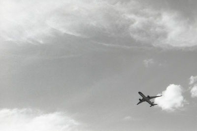 Low angle view of silhouette airplane against sky