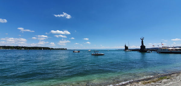 Sailboats moored on sea against sky