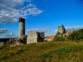 Old building in field against blue sky