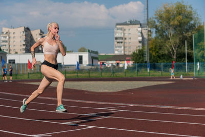 Full length of woman exercising on road