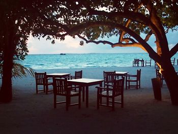 Chairs on beach against sky