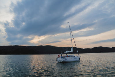 Sailboat sailing on sea against sky during sunset