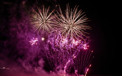 Low angle view of firework display at night