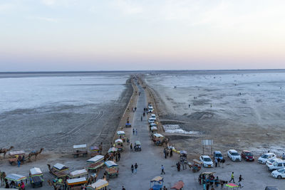 High angle view of people on beach against sky during sunset